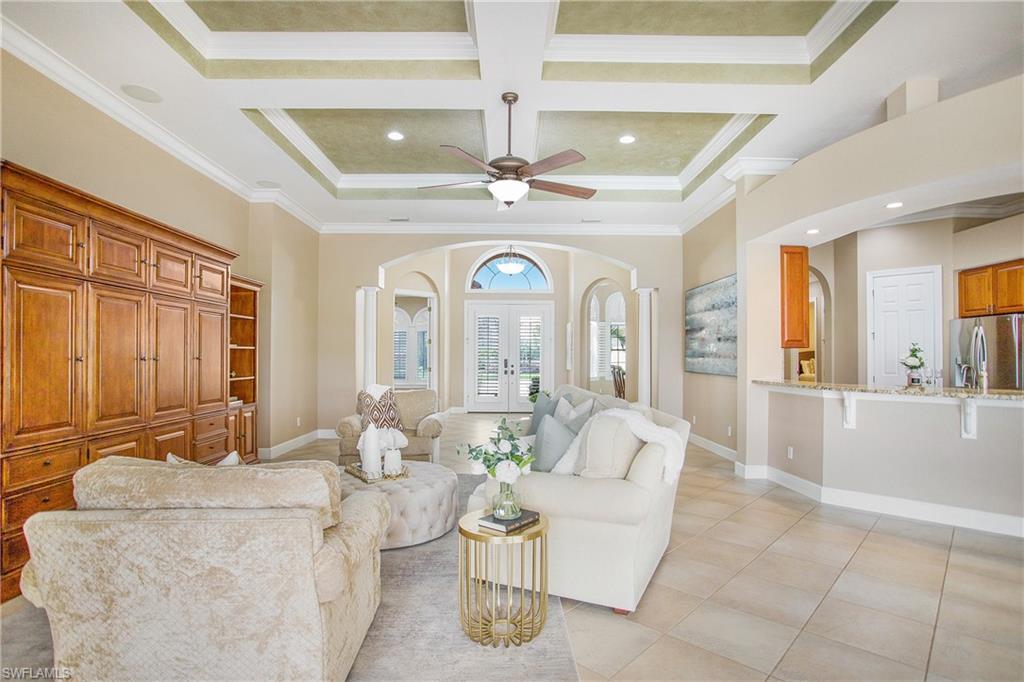 9807 Nickel Ridge Circle Naples, FL 34120 - Photo 20 of 50 a living room with furniture a chandelier and a large window