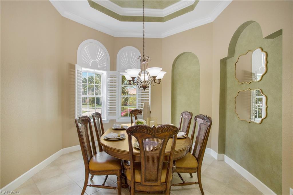 9807 Nickel Ridge Circle Naples, FL 34120 - Photo 23 of 50 a view of a dining room with furniture and chandelier
