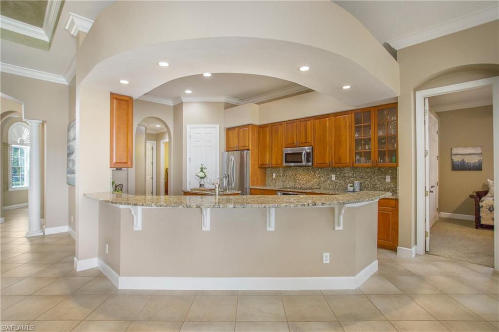 9807 Nickel Ridge Circle Naples, FL 34120 - Photo 24 of 50 a large kitchen with stainless steel appliances granite countertop a large counter top and a stove