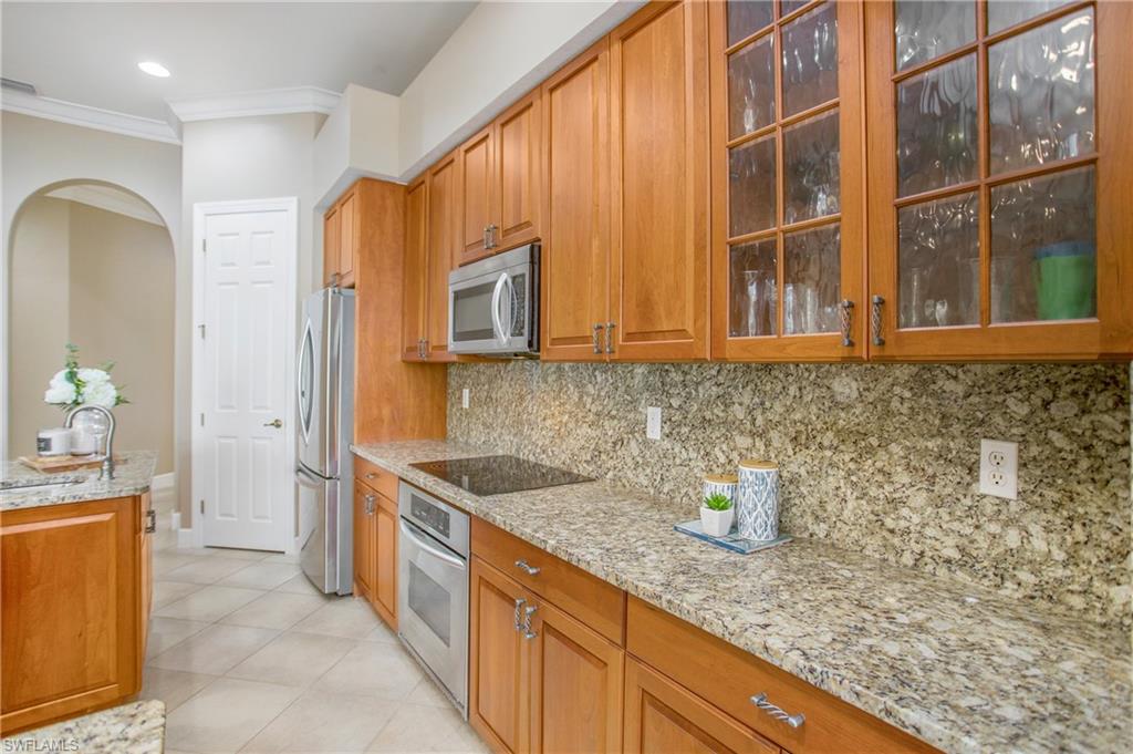 9807 Nickel Ridge Circle Naples, FL 34120 - Photo 27 of 50 a kitchen with stainless steel appliances granite countertop a sink stove and cabinets