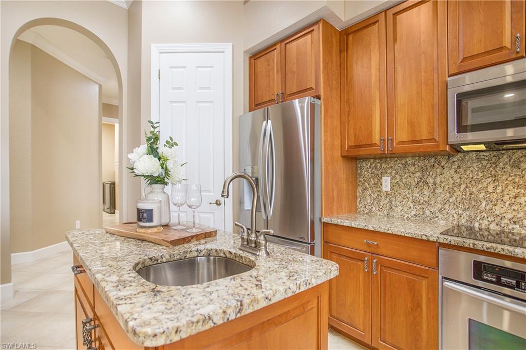 9807 Nickel Ridge Circle Naples, FL 34120 - Photo 28 of 50 a kitchen with granite countertop a sink stainless steel appliances a counter space and cabinets