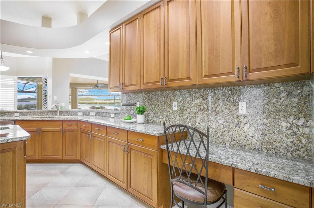 9807 Nickel Ridge Circle Naples, FL 34120 - Photo 29 of 50 a kitchen with stainless steel appliances granite countertop a sink a stove and a microwave