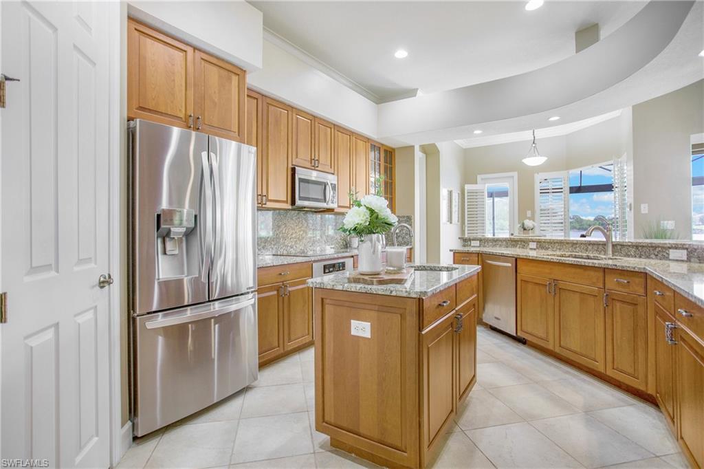 9807 Nickel Ridge Circle Naples, FL 34120 - Photo 30 of 50 a kitchen with stainless steel appliances granite countertop a refrigerator and a sink