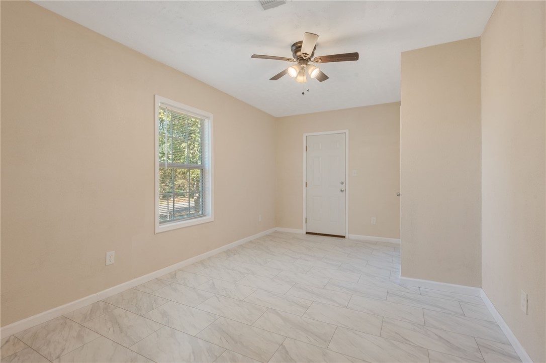 401 East 3rd Street Hearne, TX 77859 - Photo 12 of 25 an empty room with windows and fan