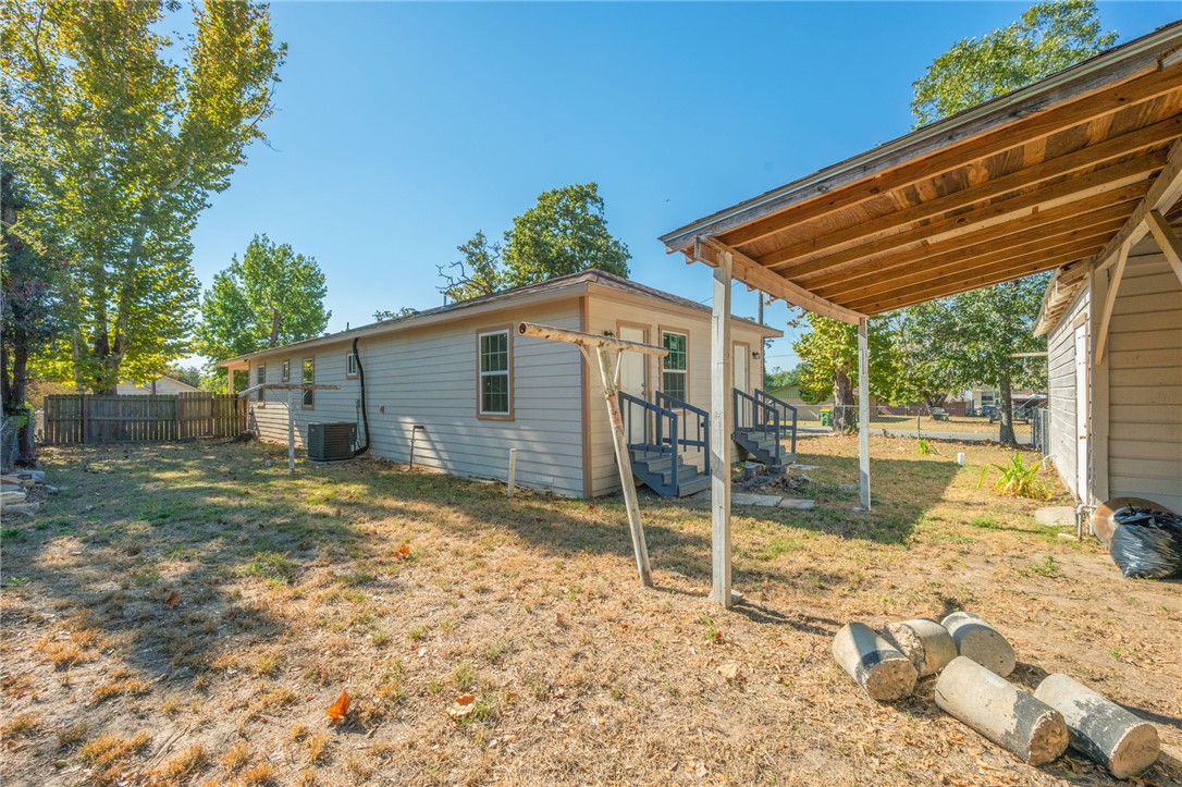 401 East 3rd Street Hearne, TX 77859 - Photo 22 of 25 a backyard of a house with table and chairs under an umbrella
