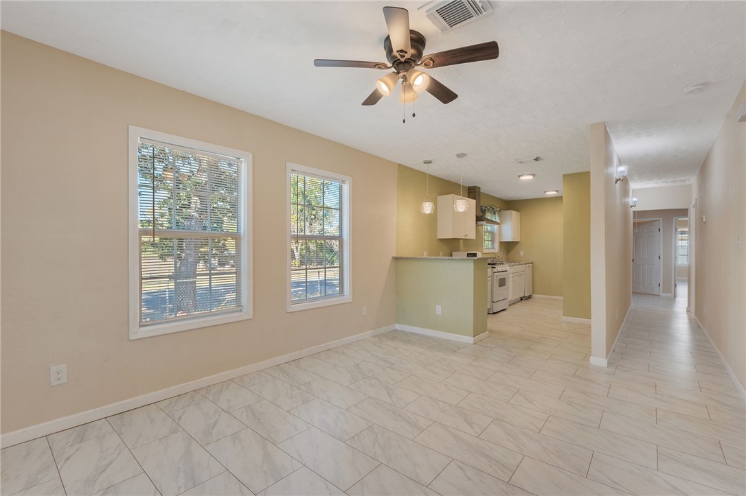 401 East 3rd Street Hearne, TX 77859 - Photo 3 of 25 a view of a big room with windows and chandelier fan