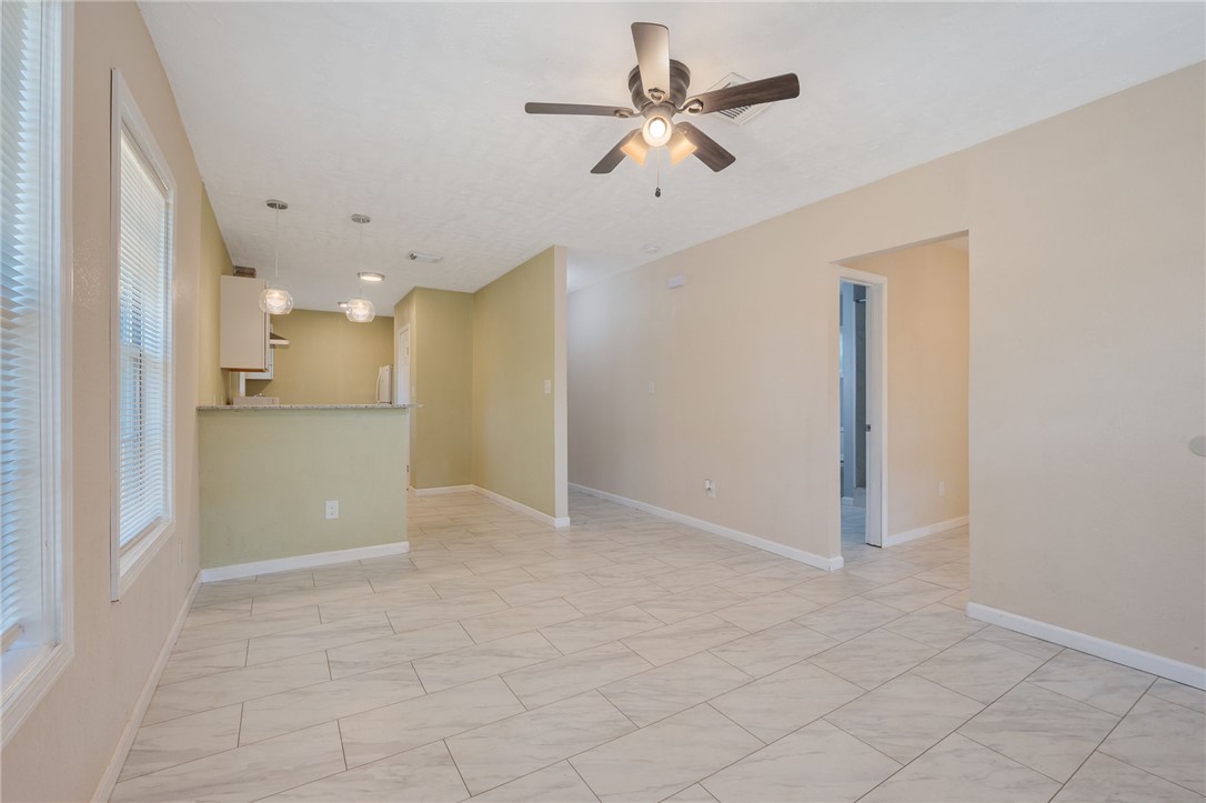 401 East 3rd Street Hearne, TX 77859 - Photo 4 of 25 a view of a livingroom with a ceiling fan & kitchen space