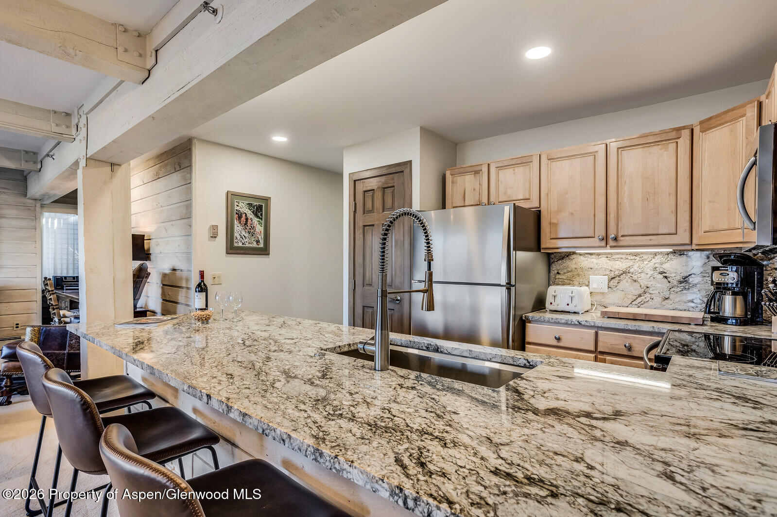 55 Upper Woodbridge Road, Unit E2 Snowmass Village, CO 81615 - Photo 20 of 41 a kitchen with granite countertop a refrigerator and a stove top oven