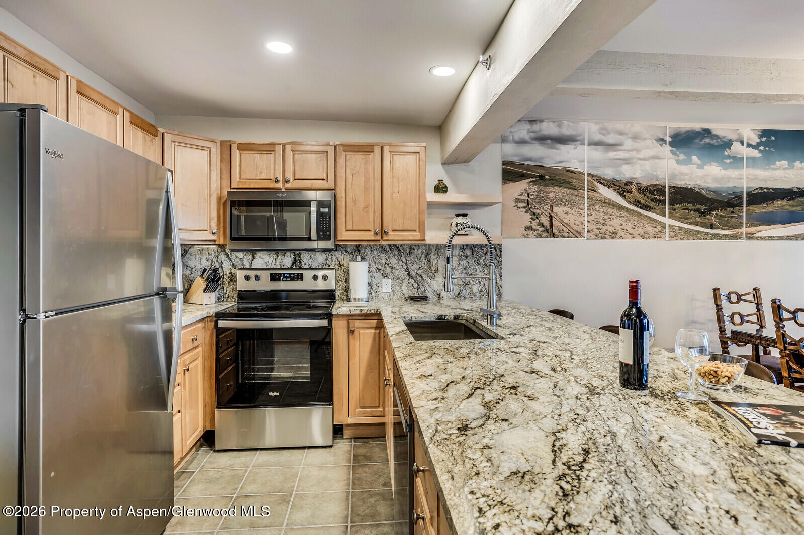 55 Upper Woodbridge Road, Unit E2 Snowmass Village, CO 81615 - Photo 22 of 41 a kitchen with stainless steel appliances kitchen island granite countertop a refrigerator and a stove
