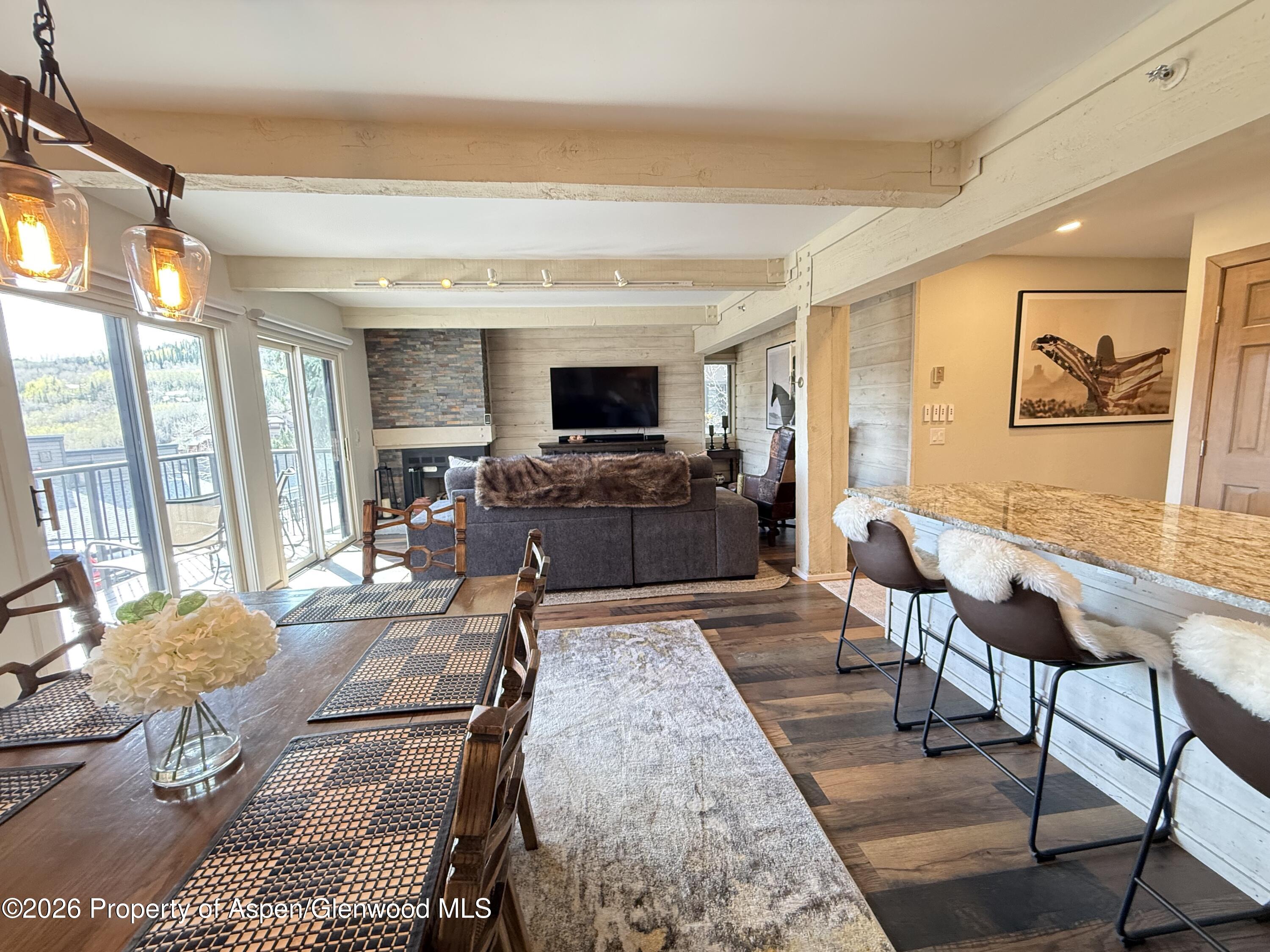 55 Upper Woodbridge Road, Unit E2 Snowmass Village, CO 81615 - Photo 7 of 41 a living room with fireplace furniture and a flat screen tv