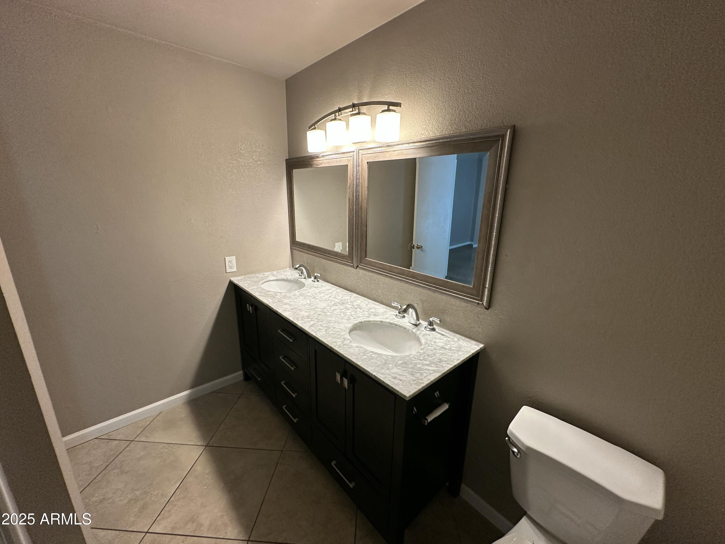4639 West Ruth Avenue Glendale, AZ 85302 - Photo 15 of 23 a bathroom with a toilet sink and mirror