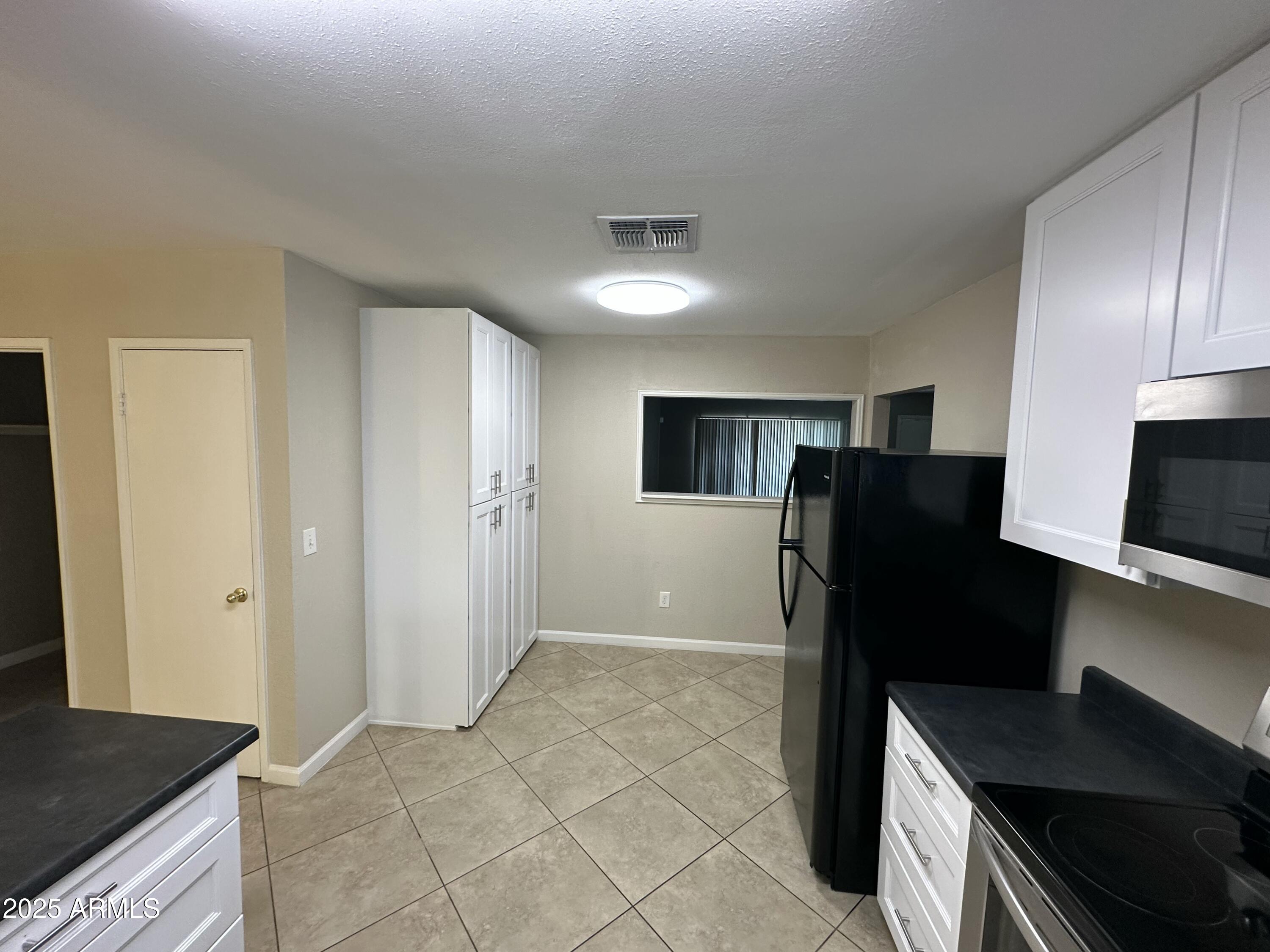 4639 West Ruth Avenue Glendale, AZ 85302 - Photo 5 of 23 a kitchen with a refrigerator and a stove top oven