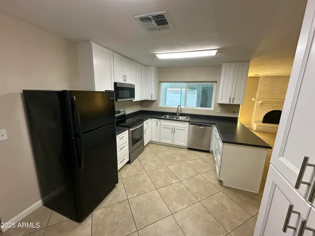 a kitchen with stainless steel appliances granite countertop a refrigerator a sink a stove a microwave and island