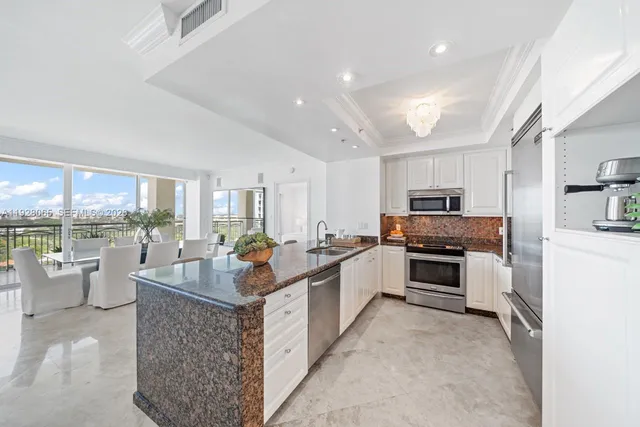 a large white kitchen with a large window and a counter top space