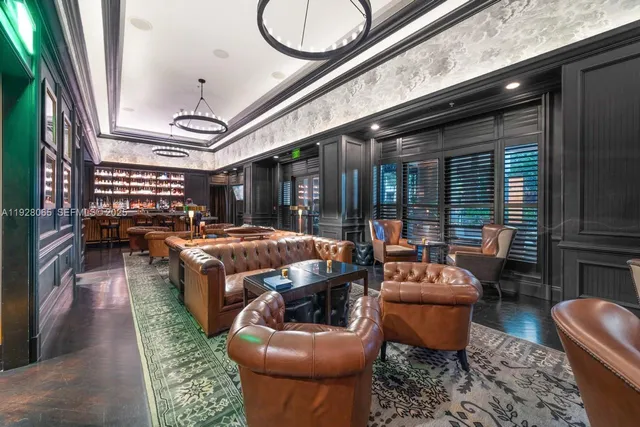 a living room with furniture a rug and a floor to ceiling window