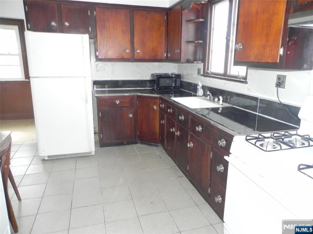 33 Center Street, Unit 1 Little Ferry, NJ 07643 - Photo 4 of 12 a kitchen with a sink a stove and a refrigerator