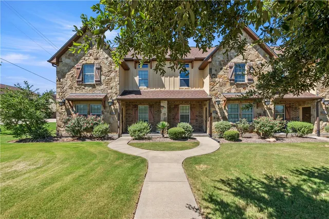 a front view of a house with yard and green space