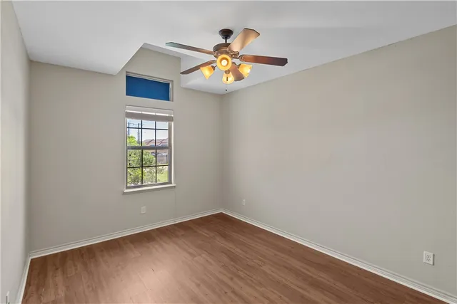 an empty room with window and chandelier fan