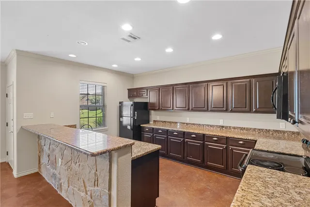 a kitchen with stainless steel appliances granite countertop a stove a sink and a refrigerator