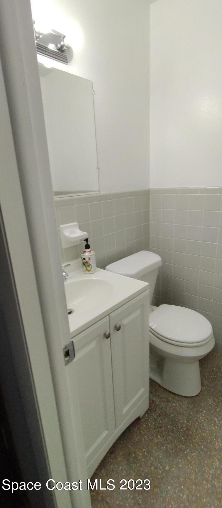 4100 Edwards Street Melbourne, FL 32901 - Photo 12 of 22 a bathroom with a sink a toilet and mirror