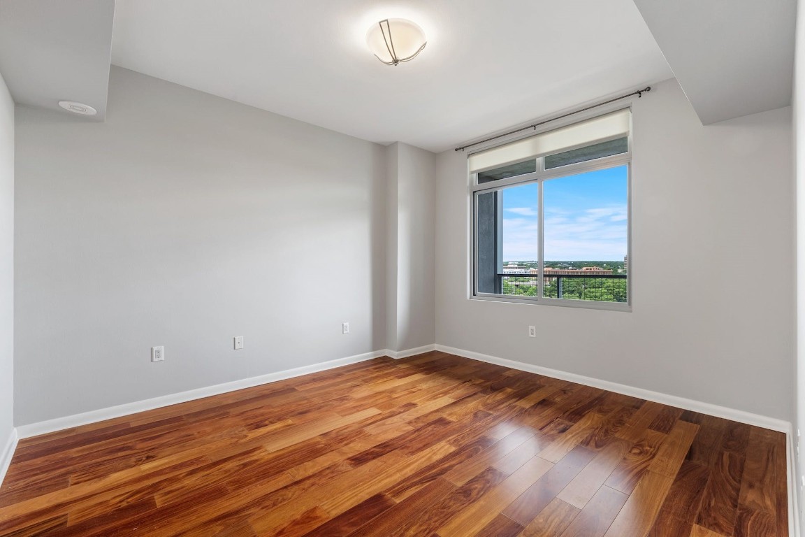 54 Rainey Street, Unit 810 Austin, TX 78701 - Photo 24 of 35 a view of an empty room with wooden floor and a window