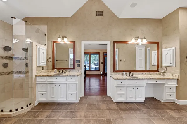 a spacious bathroom with a granite countertop sink mirror and shower