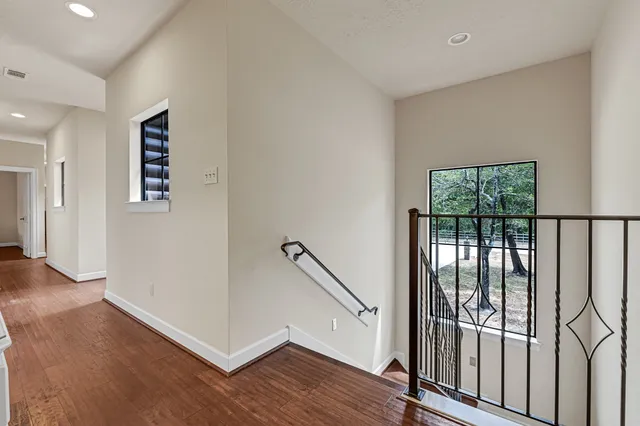 a view of a hallway with entryway wooden floor and stairs