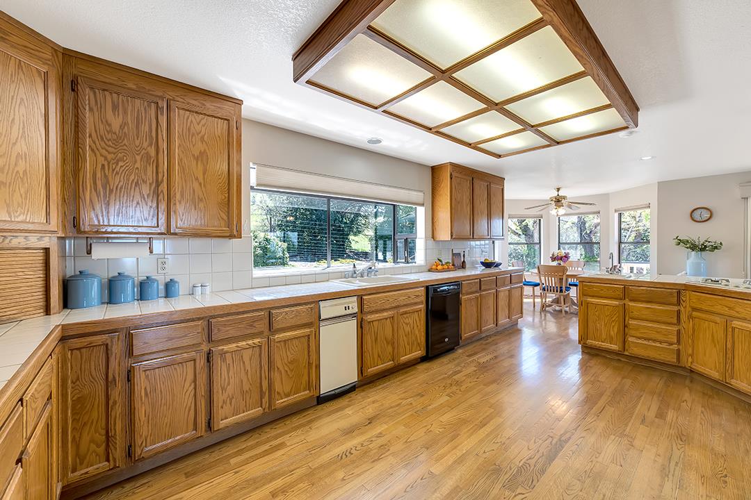 3130 Springview Lane San Jose, CA 95140 - Photo 8 of 47 a large kitchen with stainless steel appliances wooden floors and wooden cabinets