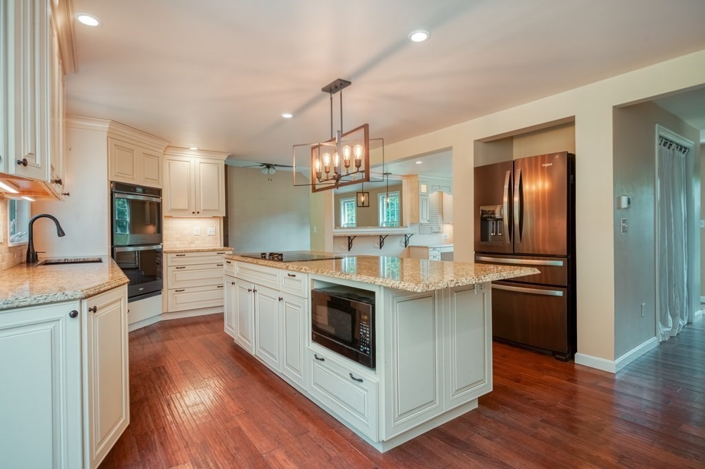 365 Turnpike Road Ashby, MA 01431 - Photo 3 of 37 a kitchen with stainless steel appliances wooden floor sink and stove