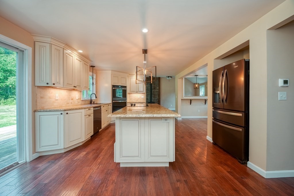 365 Turnpike Road Ashby, MA 01431 - Photo 7 of 37 a kitchen with granite countertop a refrigerator oven a sink dishwasher and white cabinets with wooden floor