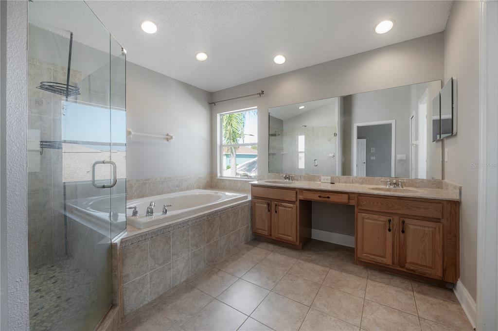 2012 Fern Ridge Court Holiday, FL 34691 - Photo 23 of 54 a large bathroom with a large tub sink vanity and granite