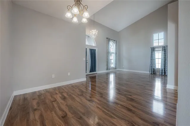 a view of a room with wooden floor and a kitchen