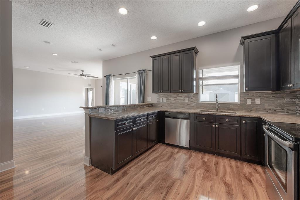 2012 Fern Ridge Court Holiday, FL 34691 - Photo 9 of 54 a kitchen with stainless steel appliances granite countertop a stove a sink and a refrigerator