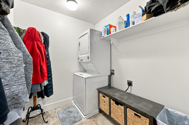 615 West 1870th Street South Payson, UT 84651 - Photo 23 of 31 Laundry area featuring a stacked washer and dryer, an overhead shelf, a built-in bench, and light-toned flooring
