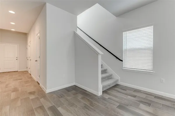 an empty room with wooden floor and entryway