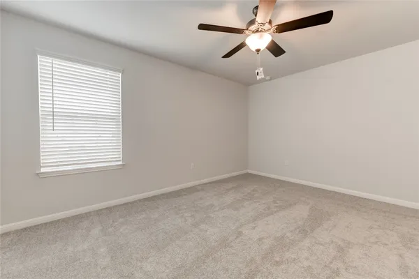 an empty room with a window and a fan