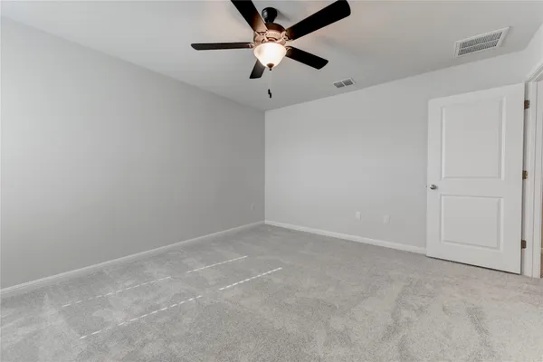 an empty room with a ceiling fan and a fan