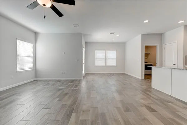 a view of empty room with wooden floor and window