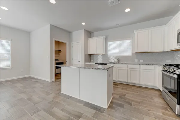 a kitchen with granite countertop white cabinets and white appliances