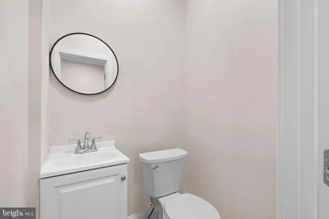 a bathroom with a toilet a sink and mirror