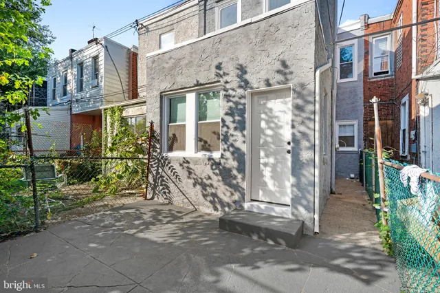 a view of a brick house with many windows next to a road