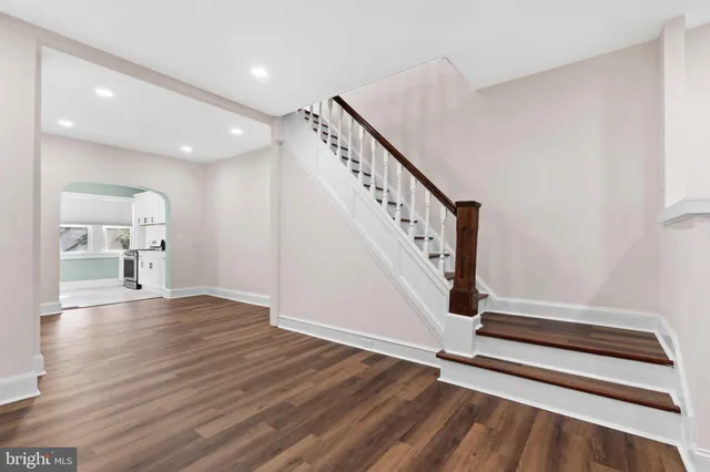 a view of a hallway with wooden floor and staircase