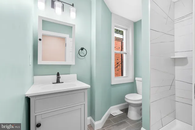 a bathroom with a sink toilet and mirror