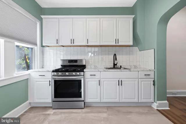 a kitchen with white cabinets and stainless steel appliances