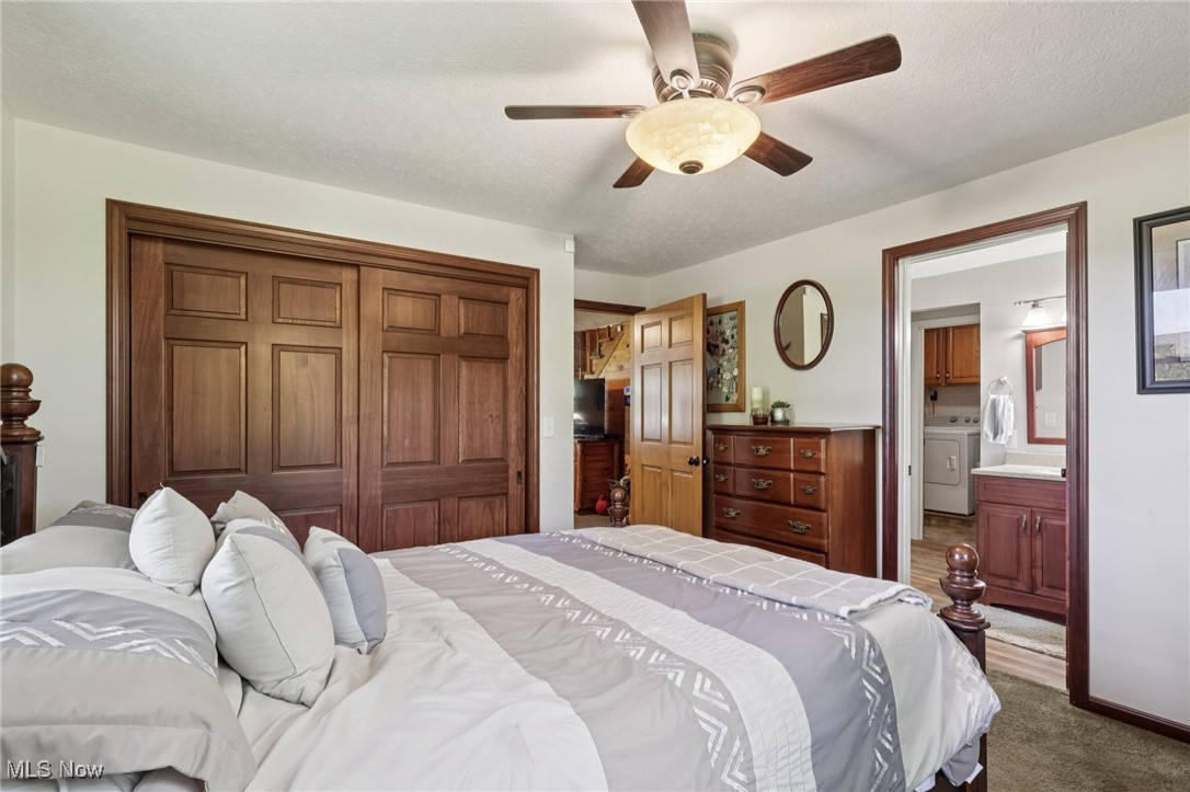 6414 Tennant Road Collins, OH 44826 - Photo 25 of 50 Bedroom with washer / clothes dryer, ceiling fan, connected bathroom, and a textured ceiling