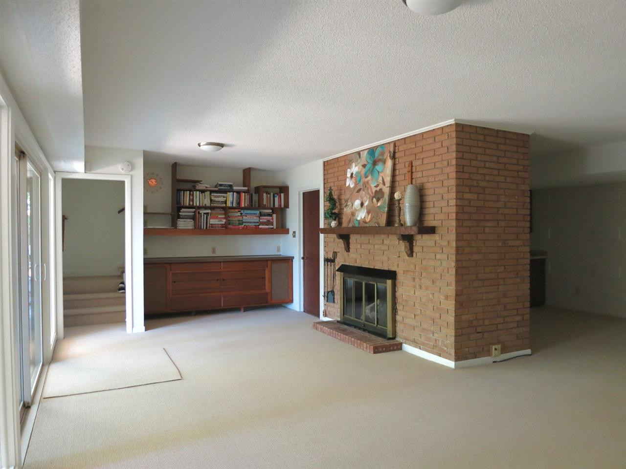 600 Davidson Street Raleigh, NC 27609 - Photo 18 of 25 On the Lower Level is the spacious Family Rm w/brick gas log FP, neutral carpet, built-in cabinetry/bookshelves, and wall of windows/sliders to the covered Patio, great for grilling & entertaining. Family Room