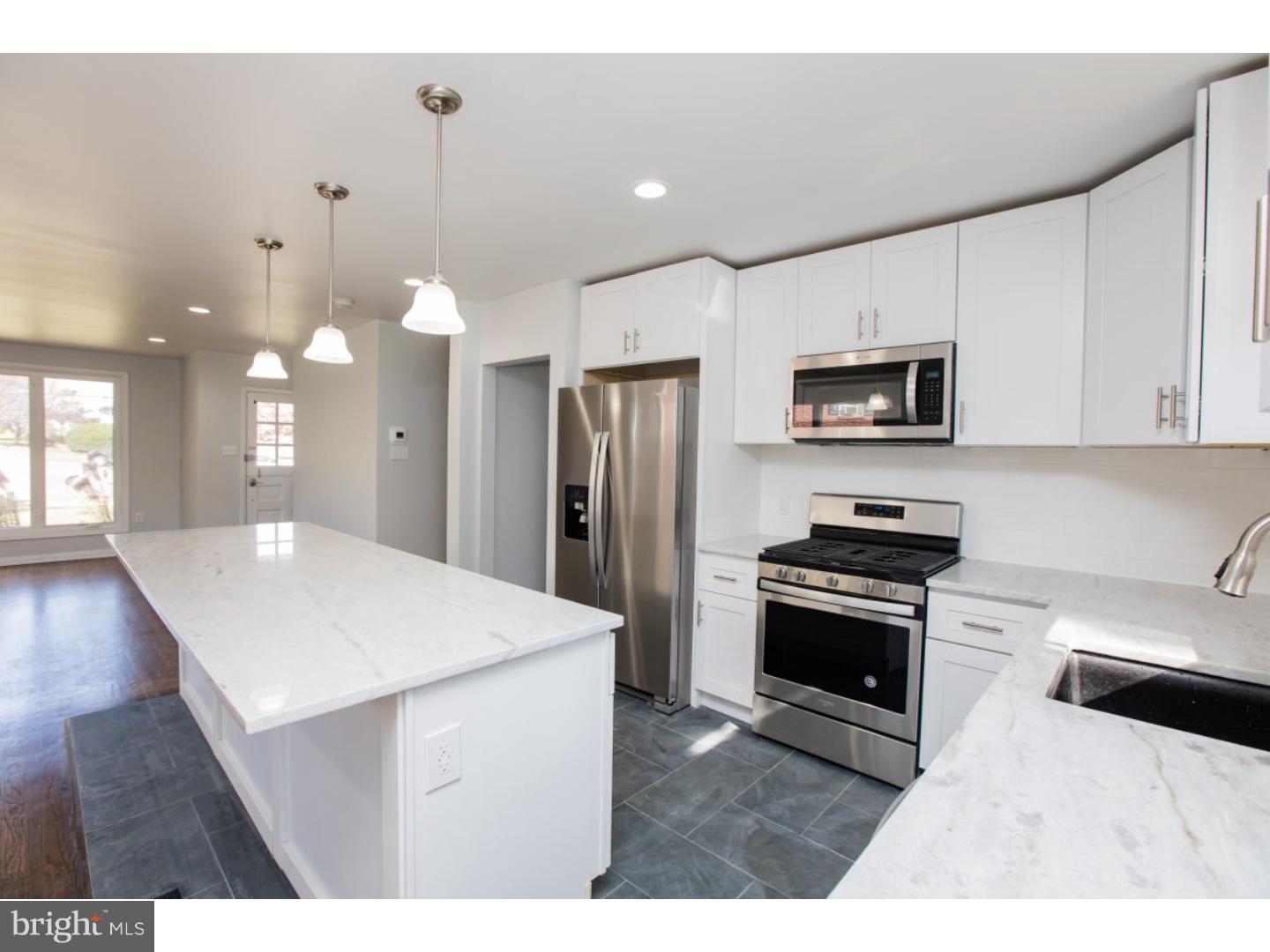 810 Coppock Lane Springfield, PA 19064 - Photo 5 of 24 a kitchen with stainless steel appliances kitchen island granite countertop a refrigerator a stove top oven a sink dishwasher and white cabinets with wooden floor