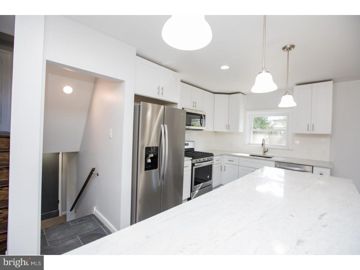 810 Coppock Lane Springfield, PA 19064 - Photo 6 of 24 a kitchen with stainless steel appliances kitchen island granite countertop a refrigerator a sink a stove and white cabinets with wooden floor