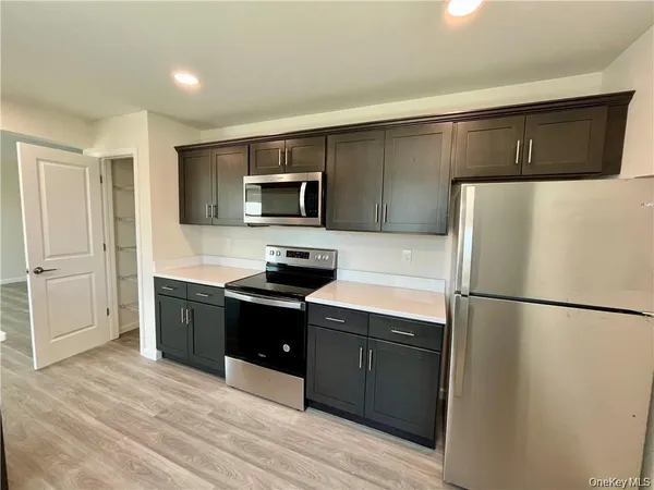 a kitchen with a refrigerator sink and wooden cabinets