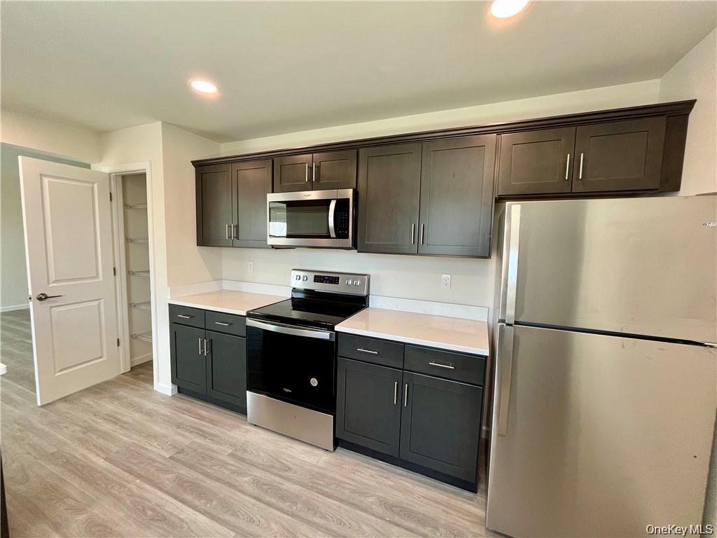 a kitchen with a refrigerator sink and wooden cabinets